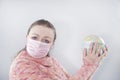 Putting a green surgical face mask on the globe sphere model. Heal the world from coronavirus covid-19 concept