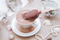 Putting ice cream in her morning coffee. Vintage porcelain mug, vintage decor, seashells and beads on the table