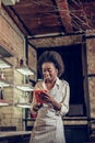 Alluring Afro-American loft bar waitress putting order information to tablet