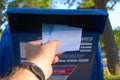 Putting letters in an outdoor metal mailbox Royalty Free Stock Photo