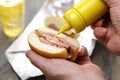 Putting mustard on a peameal bacon sandwich