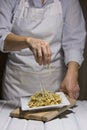 Putting parmesan cheese on bowtie pasta Royalty Free Stock Photo