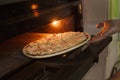 Putting seafood pizza into oven