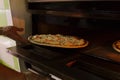 Putting seafood pizza into oven