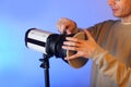 Putting a shade on a studio flash by a person Royalty Free Stock Photo
