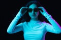 Portrait of young beautiful girl isolated on dark background in neon light Royalty Free Stock Photo