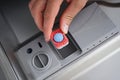 A man hand holding dishwasher detergent tablet. Putting tab into dishwasher, close up. Dishwasher machine full loaded