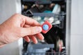 Putting tab into dishwasher, close up. A man hand holding dishwasher detergent tablet. Dishwasher machine full loaded Royalty Free Stock Photo