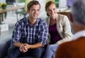 Putting their faith in their financial advisor. Smiling young couple receiving positive advice from their financial Royalty Free Stock Photo