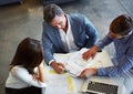 Putting their heads together. High angle shot of three businesspeople working in the office. Royalty Free Stock Photo