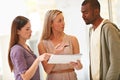 Putting their heads together. three business professionals standing and going through some paperwork together. Royalty Free Stock Photo