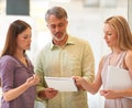 Putting their heads together. three business professionals standing and going through some paperwork together. Royalty Free Stock Photo