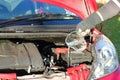 Putting water into a car radiator. Royalty Free Stock Photo