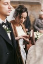 Priest putting on wedding rings on bride and groom hands during holy matrimony in church Royalty Free Stock Photo