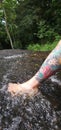 Putting your foot in the waters of the waterfall highlighting the tatoo