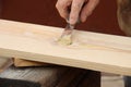 Putty knife in old man`s hand. Removing paint from a wood surface. Preparation of boards before impregnation with