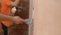 Construction worker with long trowel plastering a wall. Putty walls Royalty Free Stock Photo