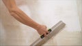 Construction worker with long trowel plastering a wall. Putty walls Royalty Free Stock Photo