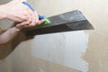 Puttying the wall with plaster putty using a wide spatula Royalty Free Stock Photo