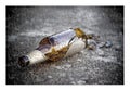 Puzzle of a broken bottle of beer resting on the ground Royalty Free Stock Photo