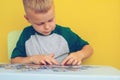 Puzzle game.Focus on the hands of a child holding puzzles.On a yellow background