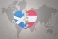 puzzle heart with the national flag of austria and scotland on a world map background.Concept Royalty Free Stock Photo