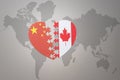 Puzzle heart with the national flag of china and canada on a world map background. Concept Royalty Free Stock Photo