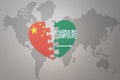 Puzzle heart with the national flag of china and saudi arabia on a world map background. Concept Royalty Free Stock Photo