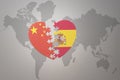 Puzzle heart with the national flag of china and spain on a world map background. Concept Royalty Free Stock Photo