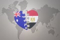Puzzle heart with the national flag of egypt and australia on a world map background. Concept Royalty Free Stock Photo