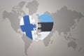 Puzzle heart with the national flag of estonia and finland on a world map background. Concept Royalty Free Stock Photo