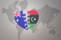 Puzzle heart with the national flag of libya and australia on a world map background. Concept Royalty Free Stock Photo
