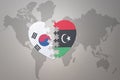 Puzzle heart with the national flag of libya and south korea on a world map background. Concept