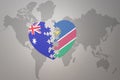 Puzzle heart with the national flag of namibia and australia on a world map background. Concept Royalty Free Stock Photo