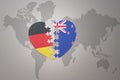 Puzzle heart with the national flag of new zealand and germany on a world map background. Concept Royalty Free Stock Photo