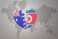 Puzzle heart with the national flag of north korea and australia on a world map background. Concept Royalty Free Stock Photo