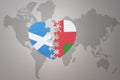 puzzle heart with the national flag of oman and scotland on a world map background.Concept