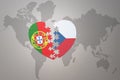 Puzzle heart with the national flag of portugal and czech republic on a world map background.Concept