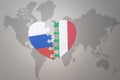 Puzzle heart with the national flag of russia and italy on a world map background. Concept Royalty Free Stock Photo