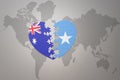 Puzzle heart with the national flag of somalia and australia on a world map background. Concept Royalty Free Stock Photo