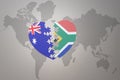 Puzzle heart with the national flag of south africa and australia on a world map background. Concept Royalty Free Stock Photo