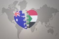 Puzzle heart with the national flag of sudan and australia on a world map background. Concept Royalty Free Stock Photo