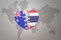 Puzzle heart with the national flag of thailand and australia on a world map background. Concept Royalty Free Stock Photo