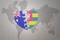 Puzzle heart with the national flag of togo and australia on a world map background. Concept Royalty Free Stock Photo