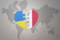 Puzzle heart with the national flag of ukraine and malta on a world map background. Concept Royalty Free Stock Photo