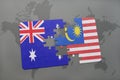 puzzle with the national flag of australia and malaysia on a world map background. Royalty Free Stock Photo