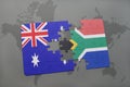 puzzle with the national flag of australia and south africa on a world map background. Royalty Free Stock Photo