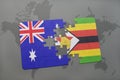 puzzle with the national flag of australia and zimbabwe on a world map background. Royalty Free Stock Photo