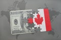 puzzle with the national flag of canada and dollar banknote on a world map background. Royalty Free Stock Photo