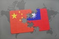 puzzle with the national flag of china and taiwan on a world map background. Royalty Free Stock Photo